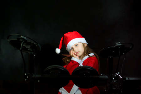 Little drummer disguised as Santa Claus playing the elettronic drum kitの写真素材