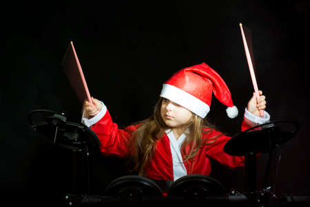 Little drummer disguised as Santa Claus playing the elettronic drum kitの写真素材
