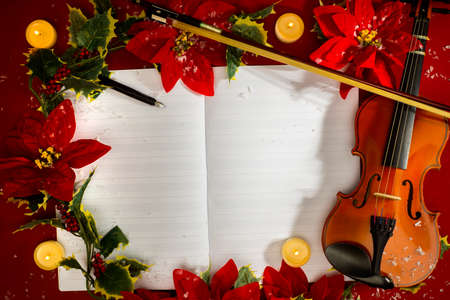 Violin and open music manuscript on the red background. Christmas conceptの写真素材