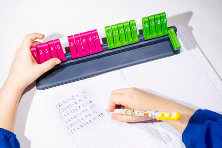 Open exercise book with colored plastic math learning tool Line 20, on white background. Close-up of...