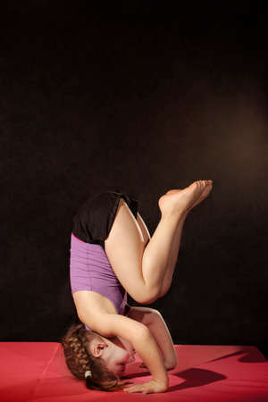 Little caucasian girl practing headstand poseの写真素材