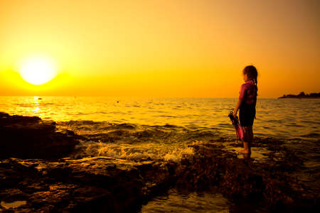 Little caucasian girlie on the rock, Croatian cost, seaboard.の写真素材