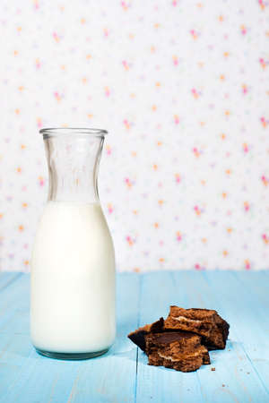 Little jug of milk and sponge cake on rustic background. Copy spaceの写真素材