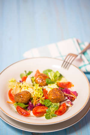 Colorful fresh vegetable salad with meatballs on rustic background. Copy space.の写真素材