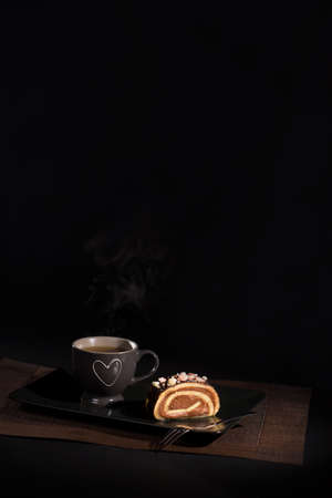 A tea cup and chocolate roll on a dishの写真素材