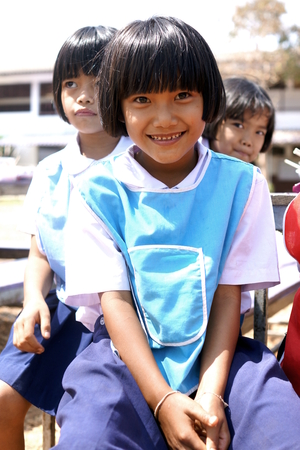 BAN BO NAM CHING, SA KAEW, THAILAND - February 10, 2014: Children eating, drinking and playing in the coutyard of a school in Ban bo nam ching, Sa kaew, Thailand.のeditorial素材
