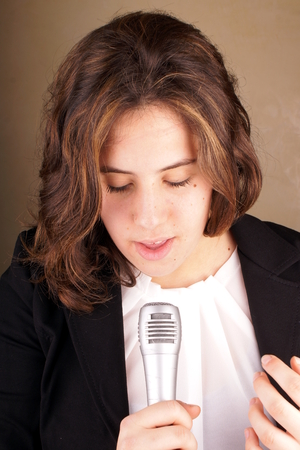 Studio shot of a young lady with microphoneの写真素材