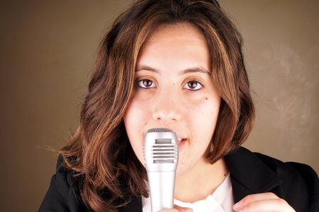 Studio shot of a young lady with microphoneの写真素材