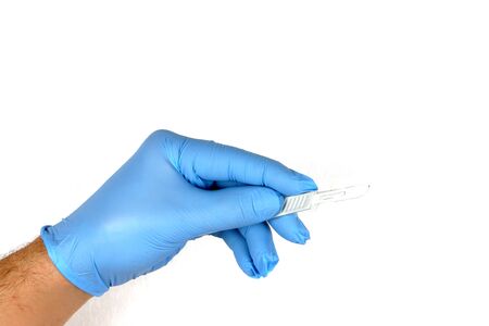 Hand with blue surgical glove and scalpelの写真素材