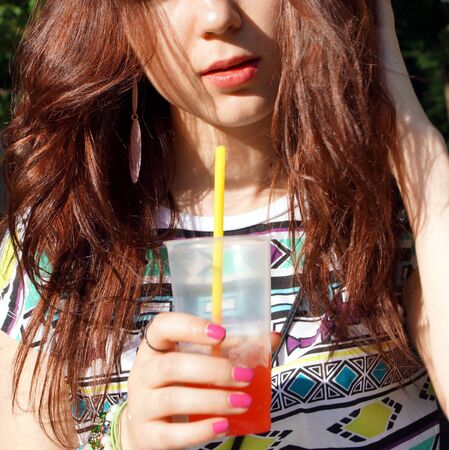 Young lady eating slush in the parkの写真素材