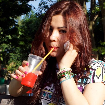 Young lady eating slush in the parkの写真素材