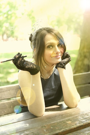 Picture of a smocking lady in the parkの写真素材