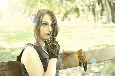 Picture of a smocking lady in the parkの写真素材