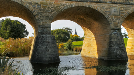 low angle view of the historic old stone bridge and st john's catholic church in richmond, tasmania