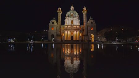 an ultra wide night shot of st charles church reflected in a pool at viennaの写真素材