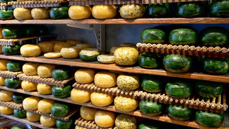 yellow and green gouda cheese wheels in an amsterdam shopの写真素材
