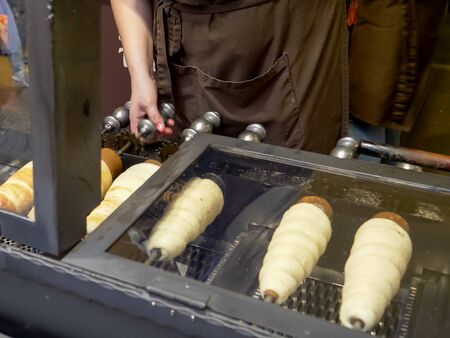 wide shot of trdelnik, a spit cake, cooking in a shop at pragueの写真素材