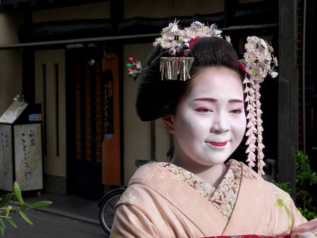 KYOTO, JAPAN - APRIL, 16, 2018: maiko looks at her photo on a camera in the gion district of kyoto