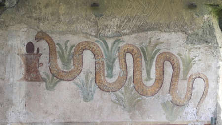 NAPLES, ITALY- JUNE, 13, 2019: shot of a serpent painting on a wall at pompeii