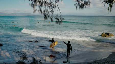 BYRON BAY, AUSTRALIA - NOV 3 2021: two longboard surfers check out the waves at wategos beach of byron bayのeditorial素材