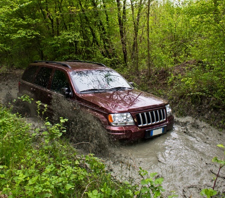Off-road passes in a puddle of mud and water