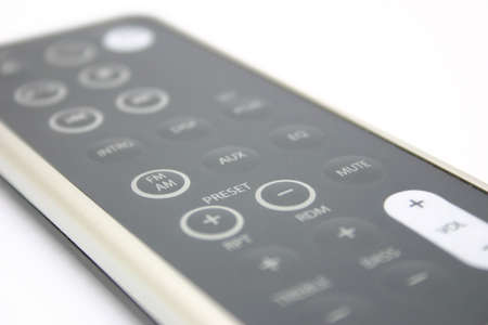 Grey remote control on a white surfaceの写真素材
