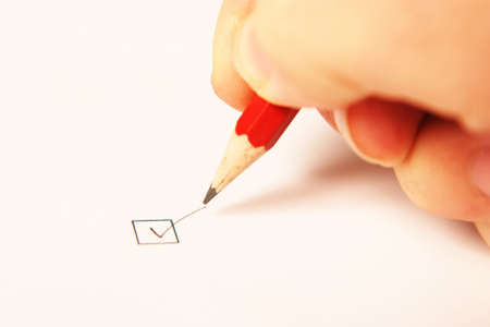 Hand writing a tick in a boxの写真素材