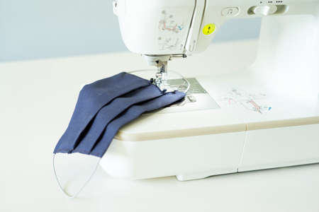 Home sewing machine sew a face medical mask during the coronavirus pandemia.