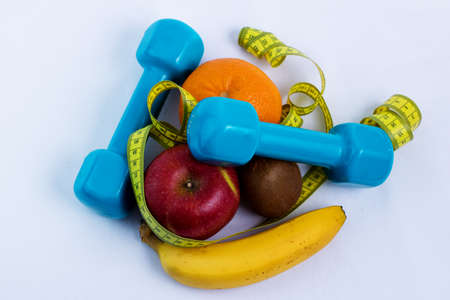 dumbbell and apple, orange, banana, kiwi (white background)の写真素材