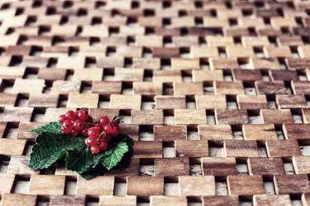 Ripe red currant berries and leaves on wood background
