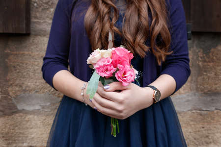close up hands holding a bouquet of the valley confirmation traditionの写真素材