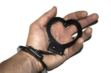 A focused heart shaped handcuff attached to an armの写真素材