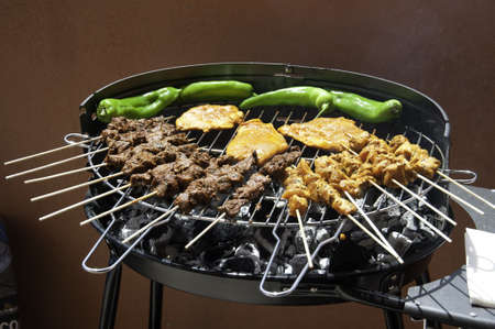 A bbq filled with different types of meat and peppersの写真素材