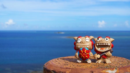 Okinawa's blue sea and smiling Shisas are Okinawa guardian lions. landscape photo copy spaceの写真素材
