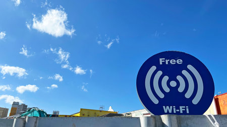 Free Wi-Fi spot sign with blue sky as background - Communication services at tourist spots and...