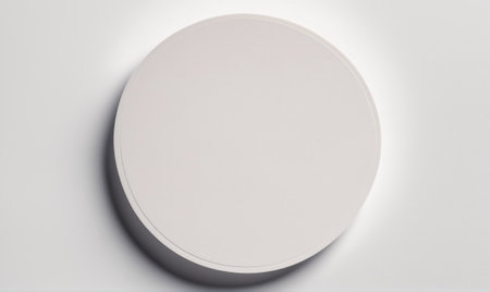 A white round light fixture is mounted on a white wallの素材