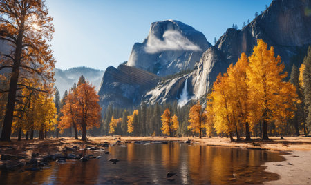 A calm river flows through the valley of Yosemite National Park, framed by tall trees and a dramatic mountain peak on a sunny autumn dayの素材