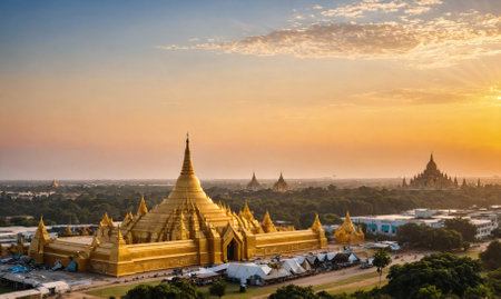 A golden pagoda stands tall against a vibrant sunset sky in Bagan, Myanmarの素材