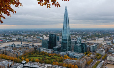 The Shard pierces the cloudy sky in London, surrounded by a cityscape teeming with lifeの素材