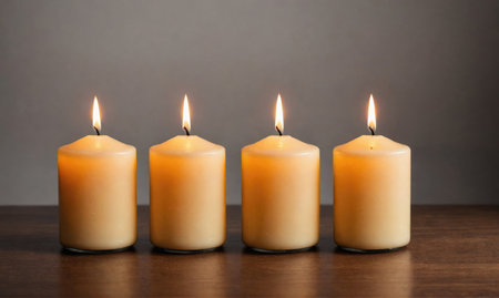 Four candles are burning brightly on a wooden tableの素材
