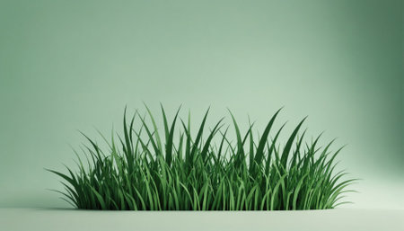 A patch of green grass grows against a soft green backgroundの素材