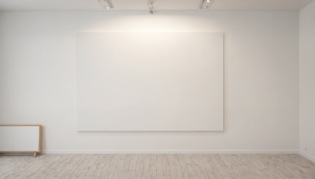 A large, empty canvas hangs on a white wall in a galleryの素材