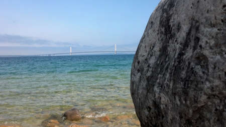 Mackinac Bridge with boulder and Lake Michigan in foregroundの写真素材