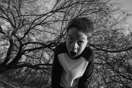 Boy in the forest screams in fearの写真素材