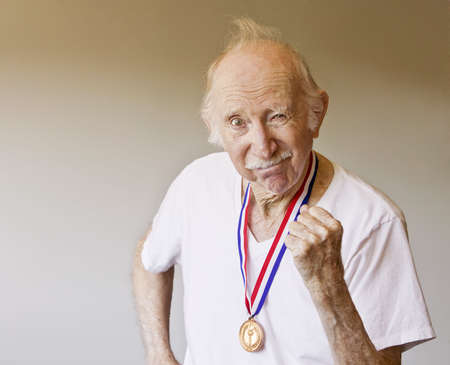 Senior Citizen Posing with a Gold Medalの写真素材