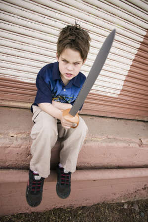 Angry Young Boy Pointing a Plastic Swordの写真素材