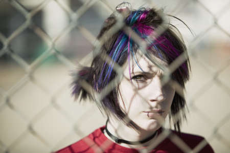 Young Punk Girl Being Shadowed By Chain Linkの写真素材