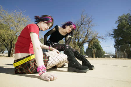 Two Punk Girls Sitting on a cement playgroundの写真素材