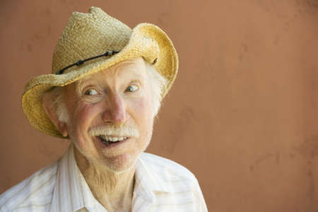 Senior Citizen Man Smiling in a Straw Cowboy Hat With Copy Spaceの写真素材