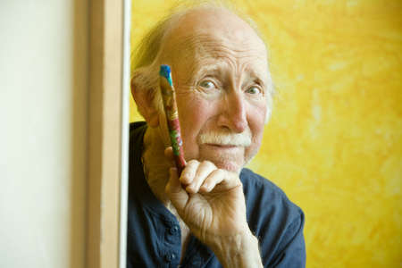 Elderly painter working on a large canvasの写真素材